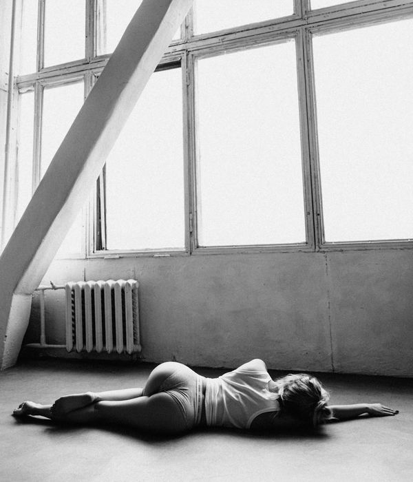 Woman performing a graceful yoga pose in a bright, serene studio.